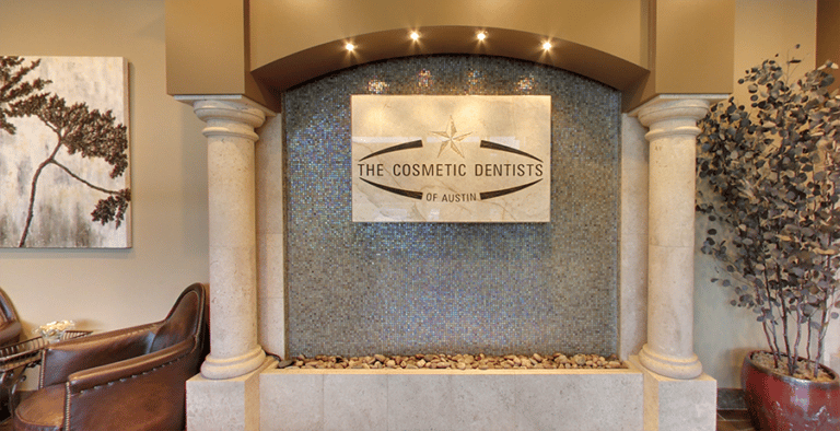Spacious lobby featuring The Cosmetic Dentists of Austin's logo on the wall, epitomizing the practice's brand of luxury dental care.