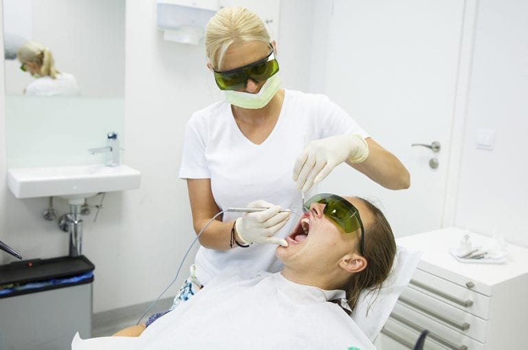 Dentist at The Cosmetic Dentists of Austin using a diode laser for advanced periodontal care, patient treatment.